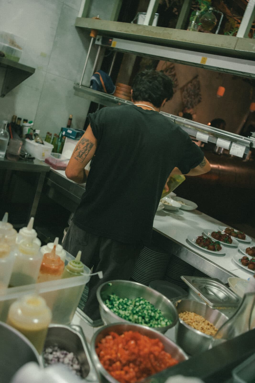 A cook at work in the kitchen at TEJÁ, bowls of prepared ingredients in front of him.