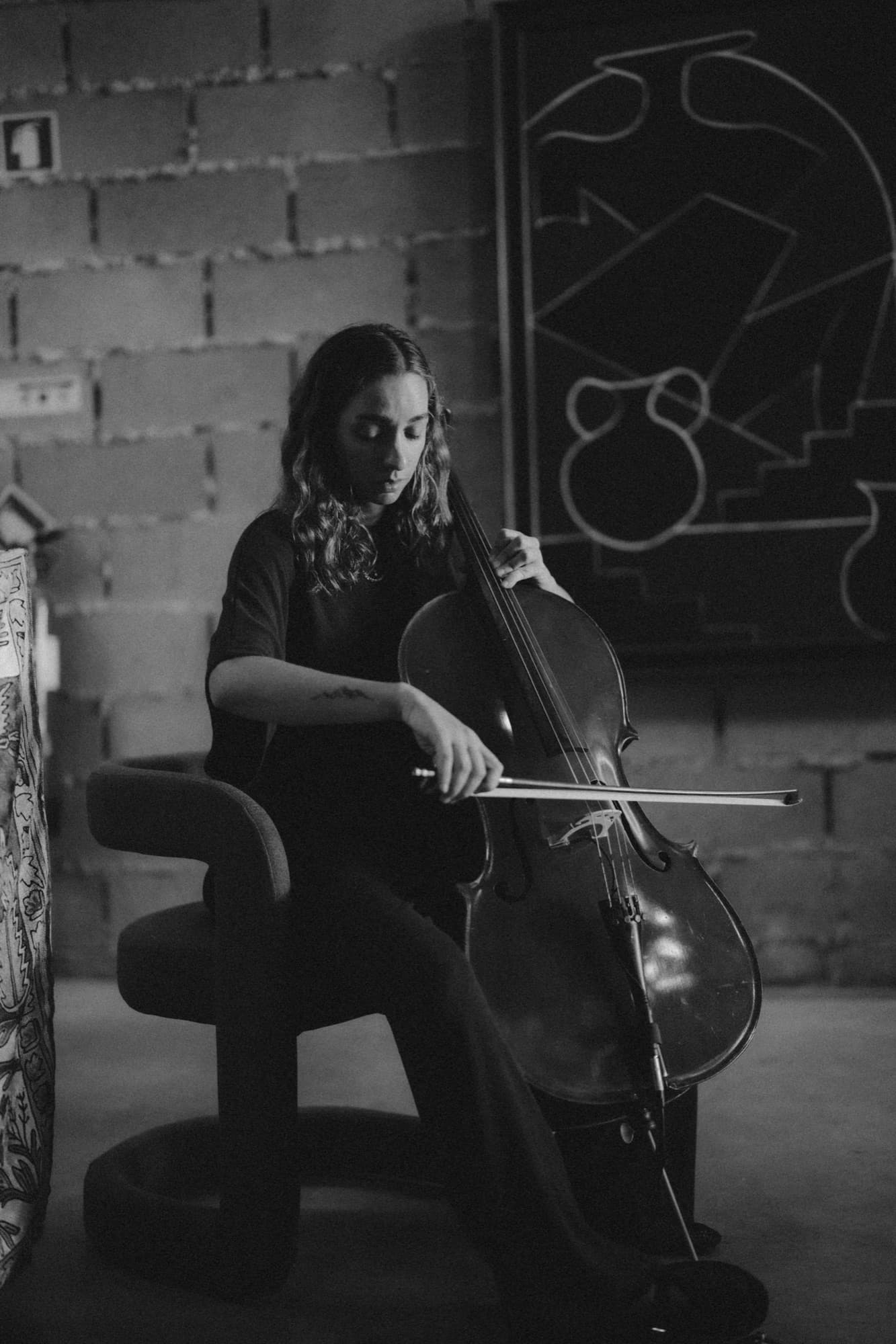 A cellist playing in the hall, in black and white.