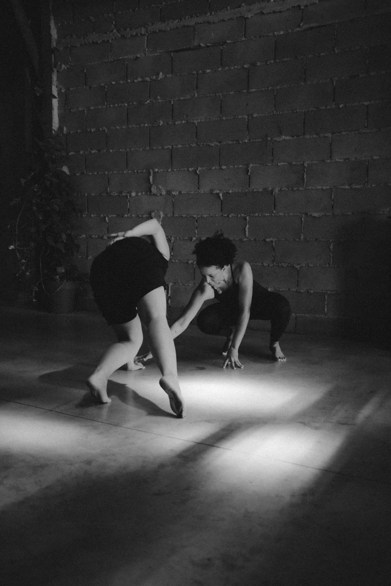 A dancer moving across the floor of the hall, in black and white.