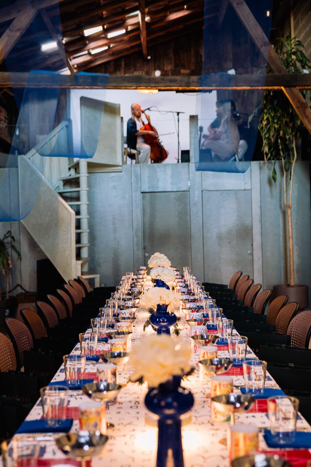 A long table laid down the hall, musicians playing at its head.