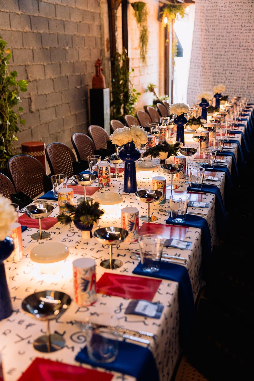 The long table laid for dinner, candles and plates along it.