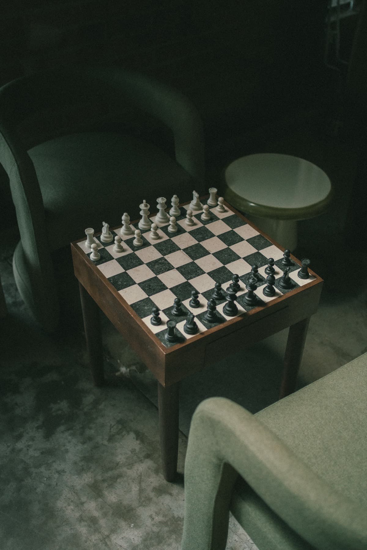 A chess board on a small table in the lounge.