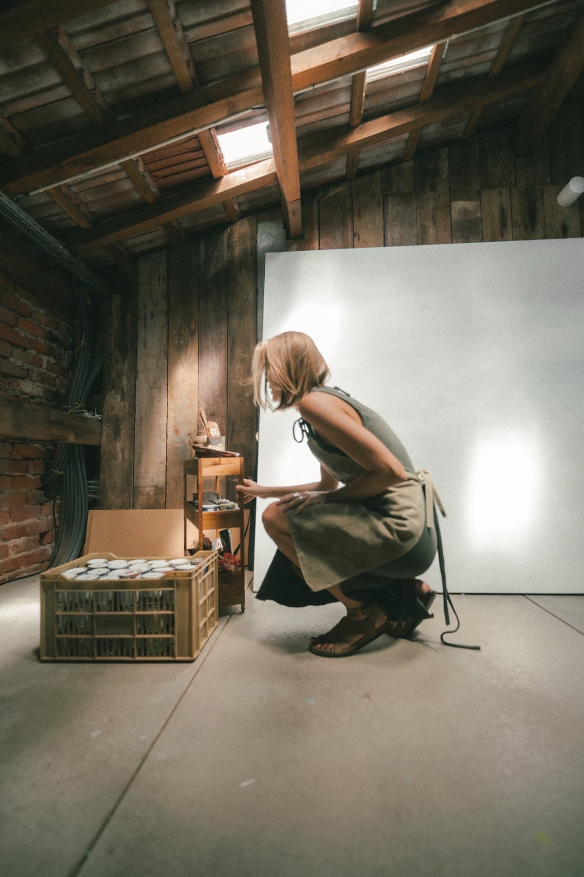 A woman looking through a crate of records under the warehouse roof.