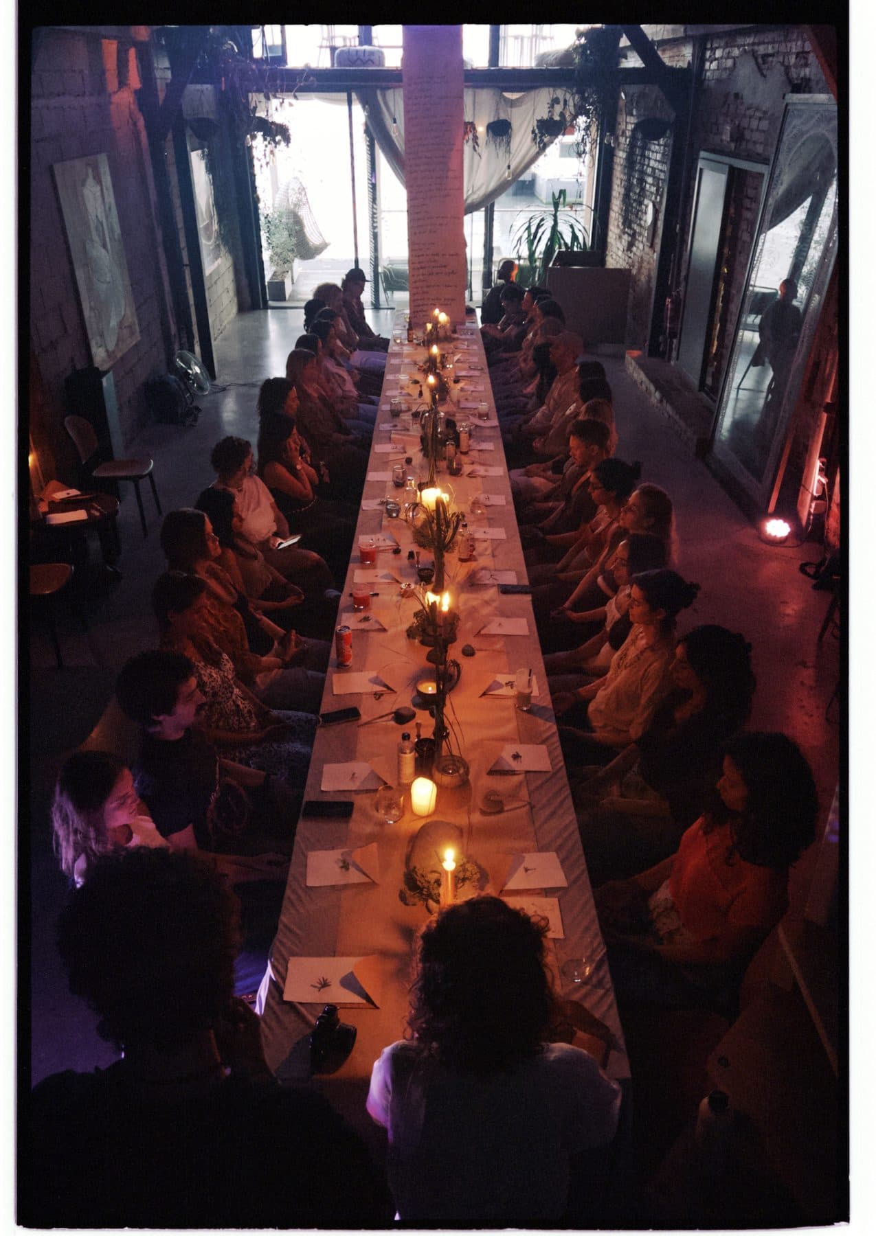 The long table at TEJÁ, full of people raising their glasses under the high roof.